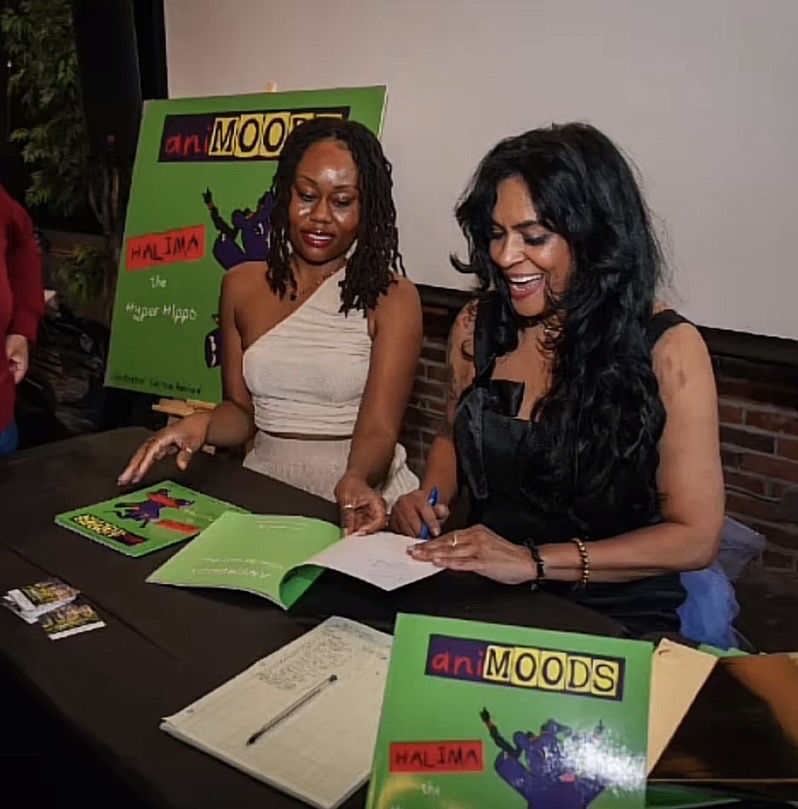 An author signing copies of her children's book at a launch event